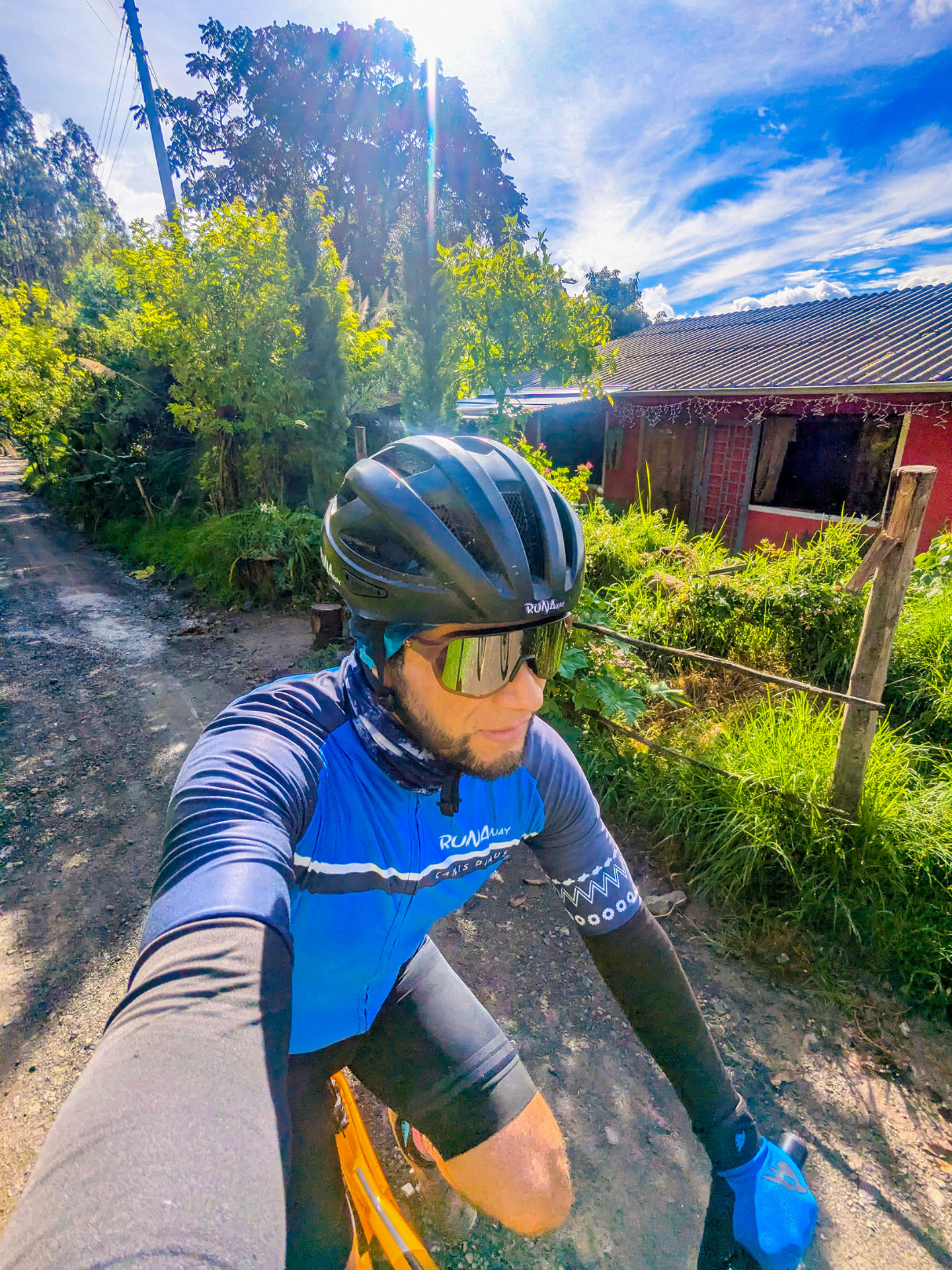 Selfie de un ciclista en un camino rural bajo el sol andino