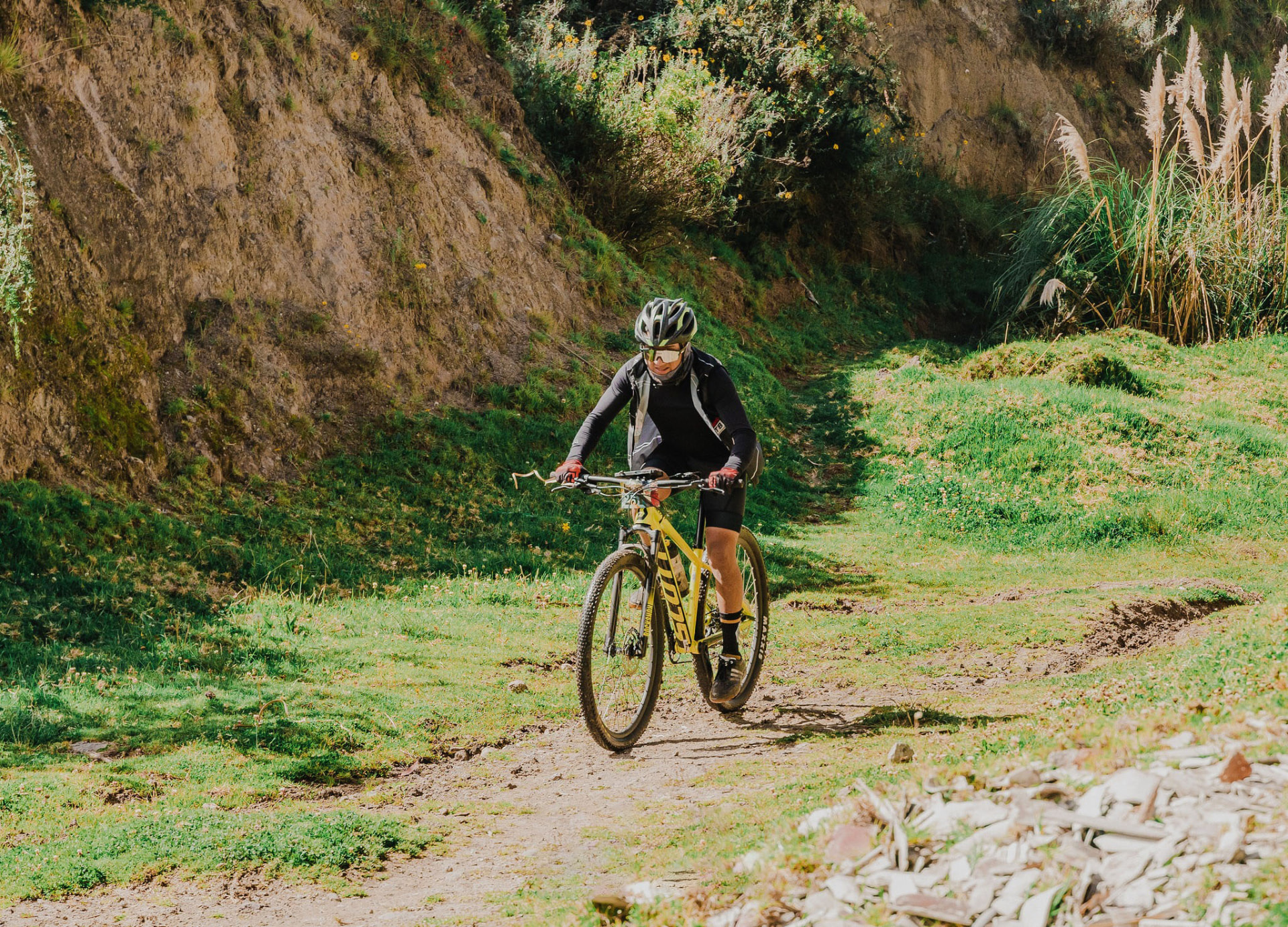 Ciclista descendiendo por un sendero junto a un talud de tierra